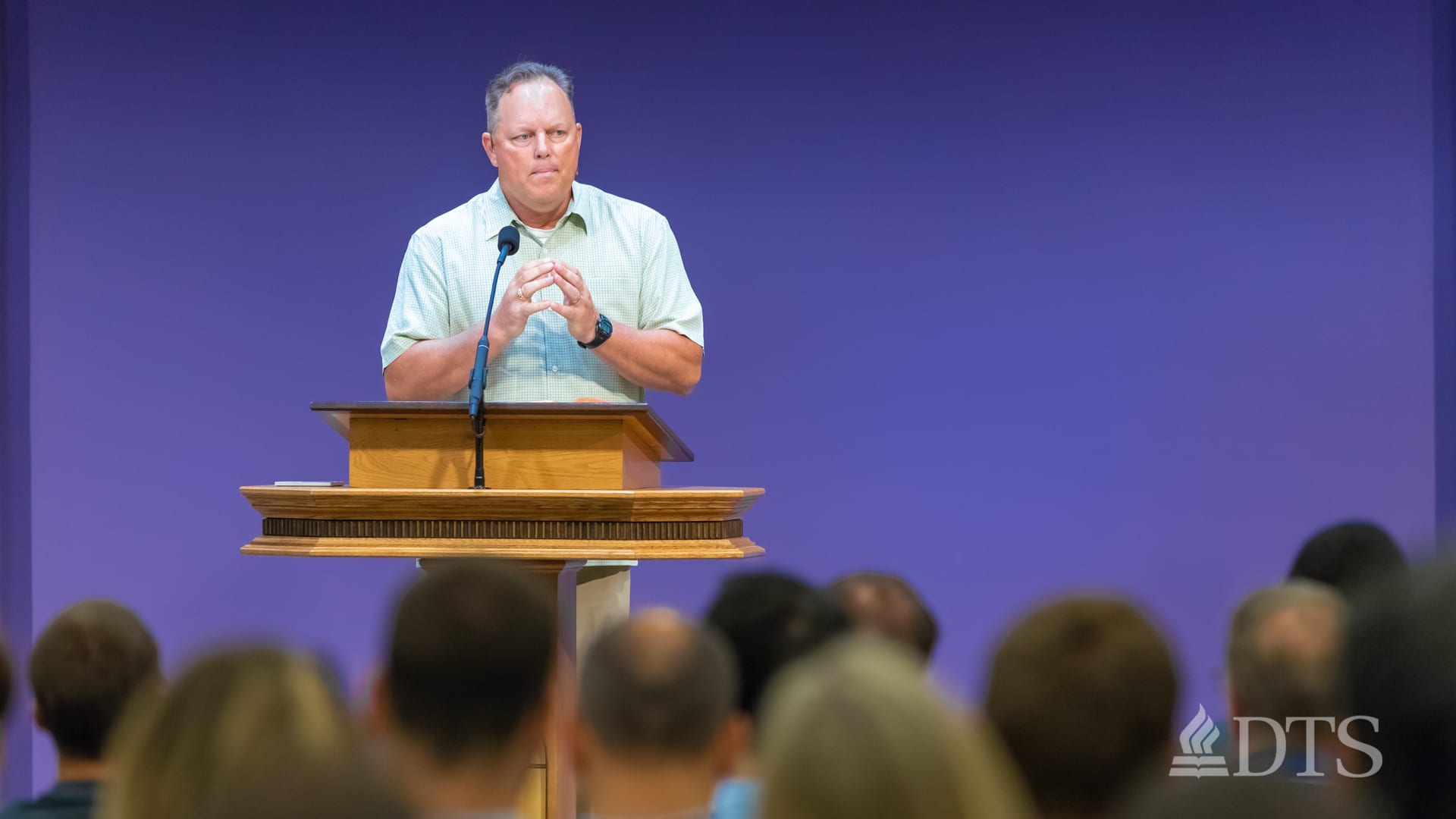 man standing at podium speaking at DTS Chapel