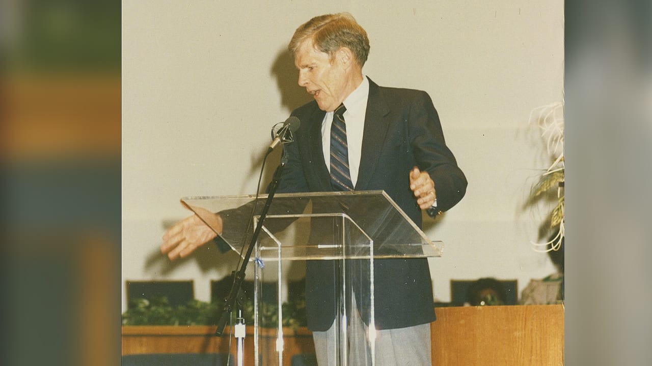 Dr. Haddon Robinson standing at podium speaking into a microphone