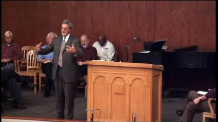man standing next to podium speaking at DTS Chapel