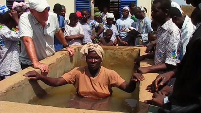 Woman being baptized in outdoor church service
