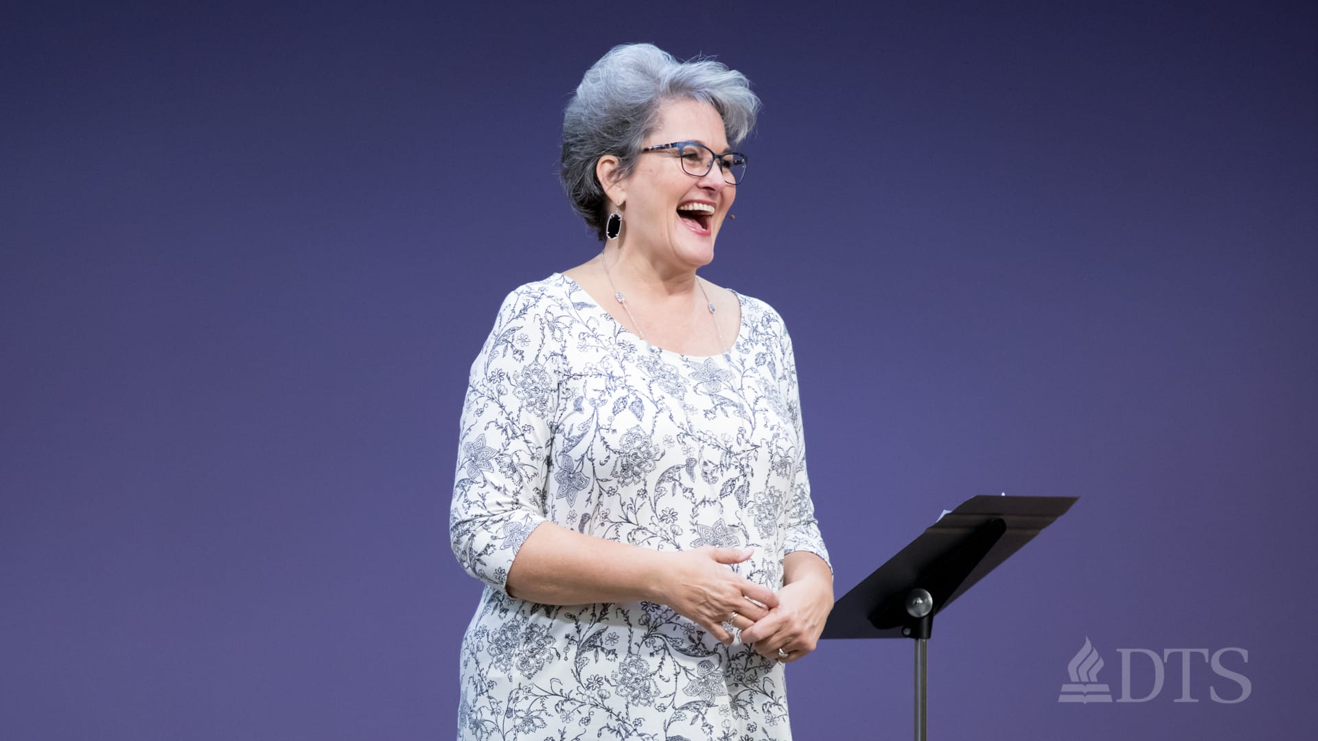 woman standing on stage speaking at DTS Chapel