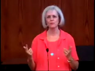 woman standing at podium speaking at DTS Chapel