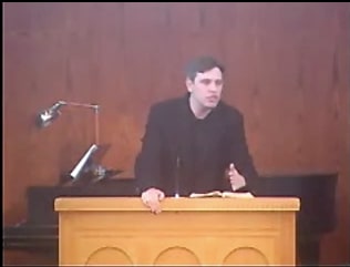 man standing at podium speaking at DTS Chapel