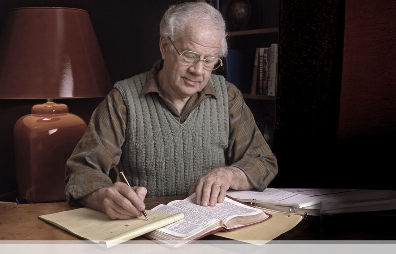Dr. Dwight Pentecost studying the Bible at his desk