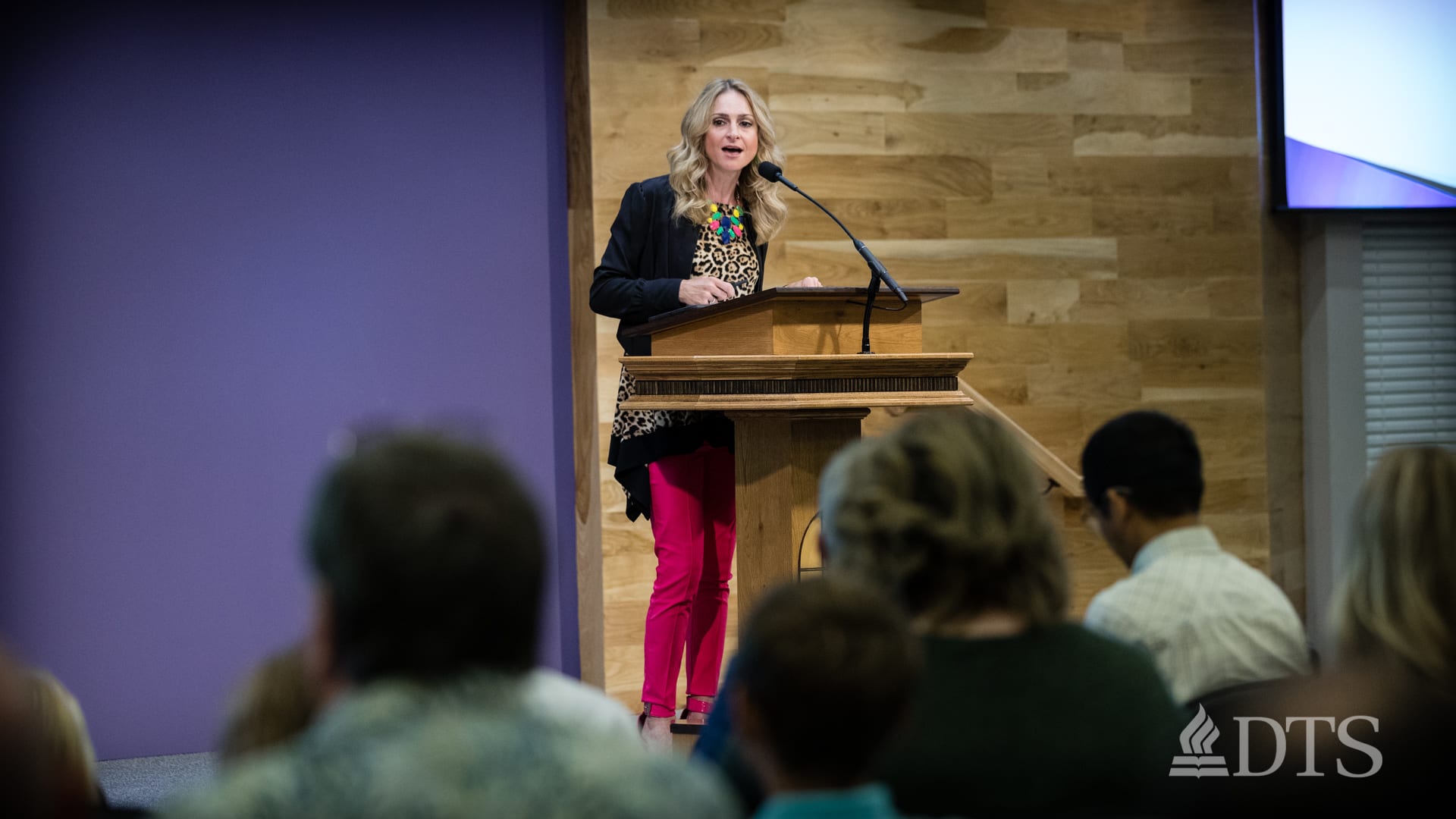 woman standing at podium speaking at DTS Chapel