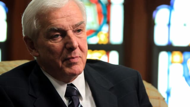 Dr. David Jeremiah seated in front of stained-glass windows