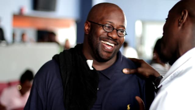 Dr. Eric Mason laughing while talking with a man