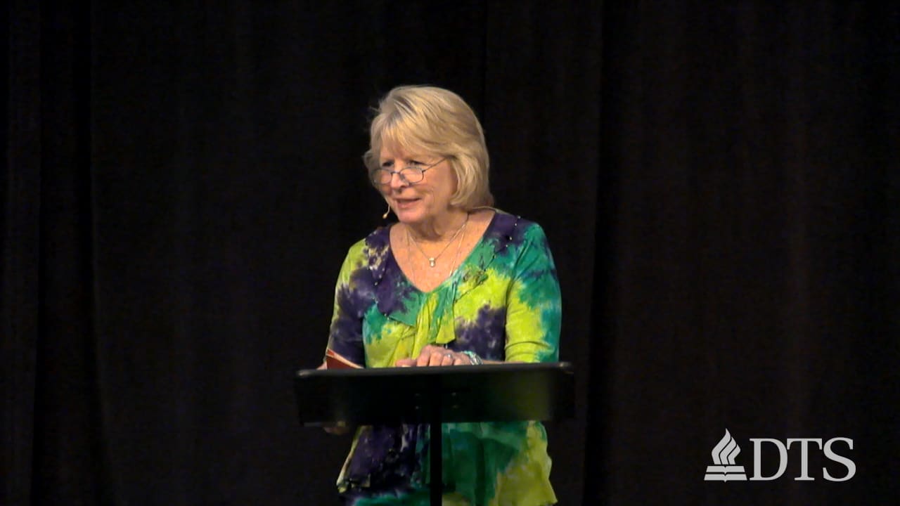 woman standing at podium speaking at DTS Chapel