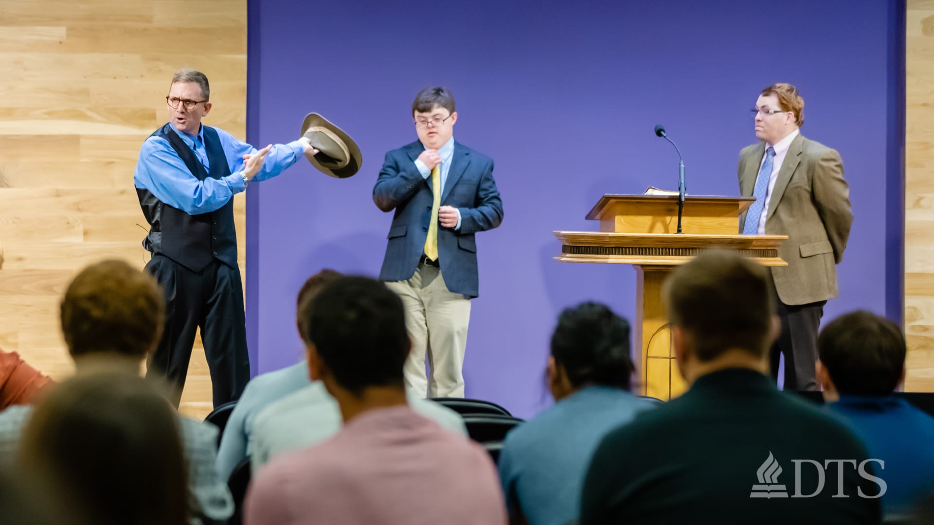 three men on stage while speaking at DTS Chapel