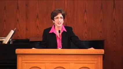 woman standing at podium speaking at DTS Chapel