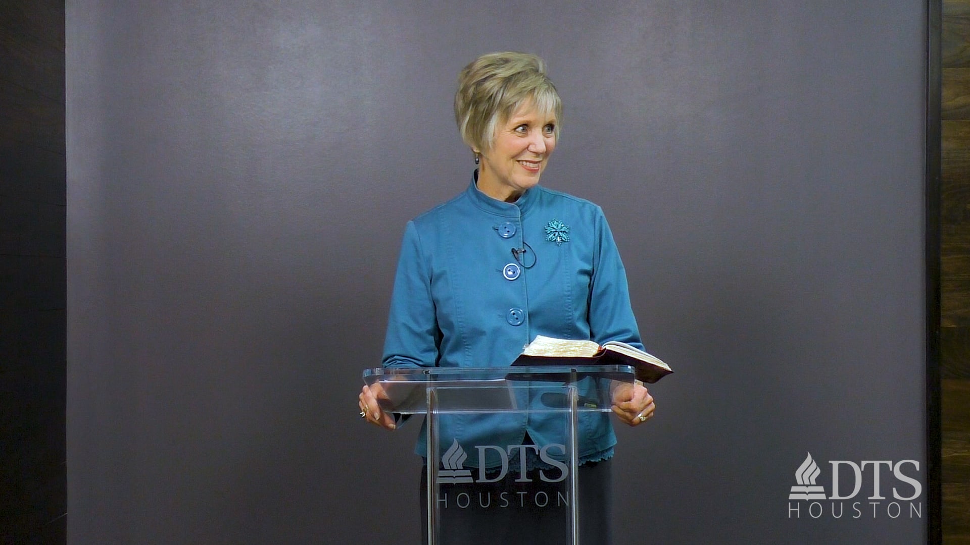 woman standing at podium speaking at DTS Chapel