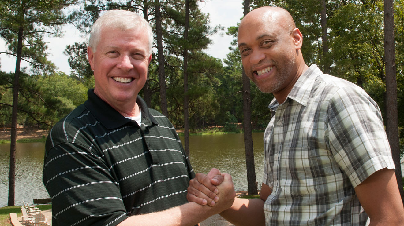 Joe Allen and Patrick Thomas shaking hands outdoors