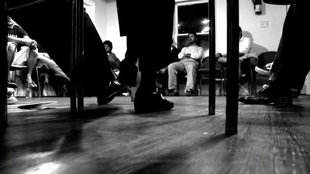 group of men seated in a circle talking