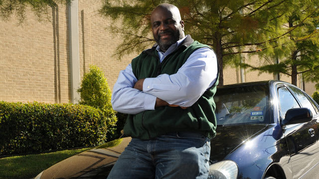 Man seated on the hood of a car at the edge of DTS campus
