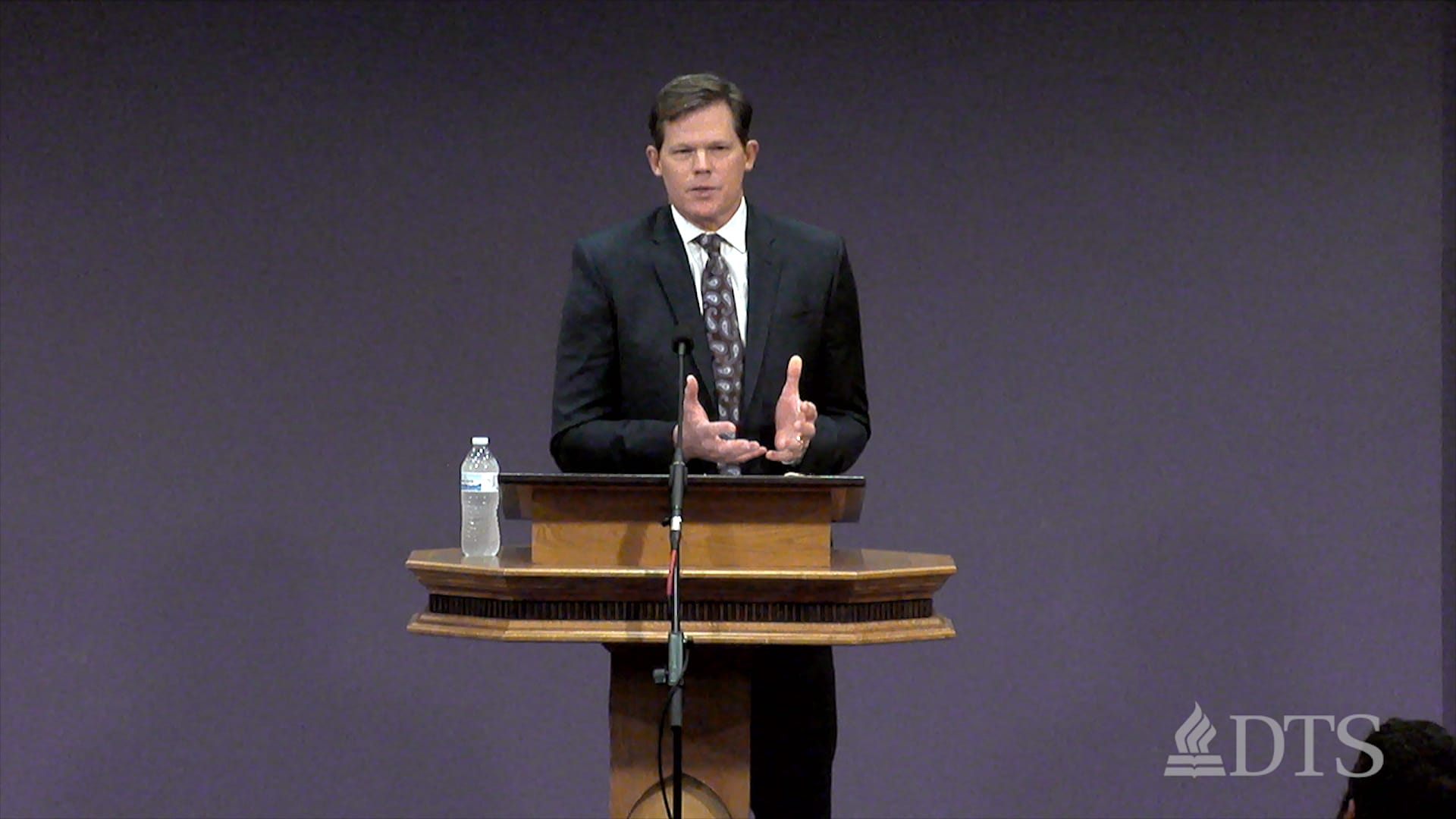 man standing at podium speaking at DTS Chapel