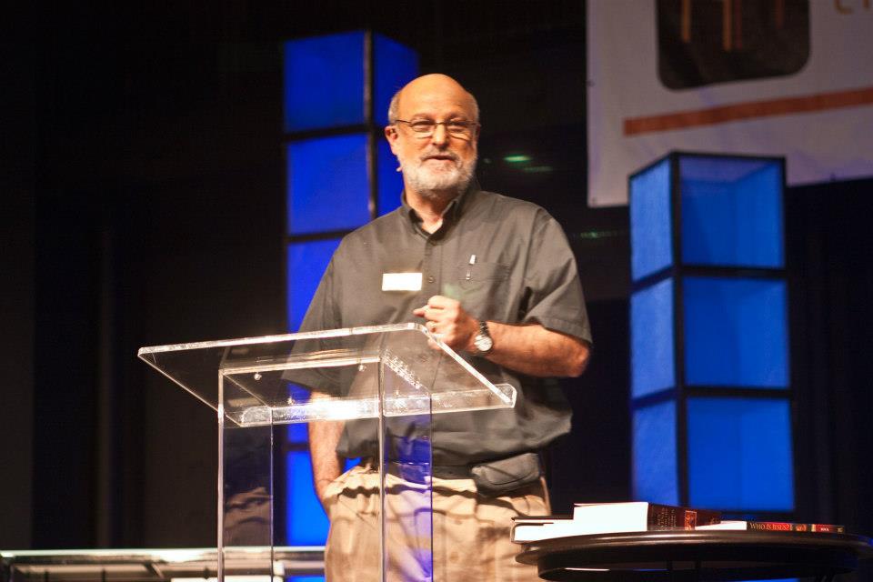 Dr. Darrell Bock speaking at a podium at The Table conference