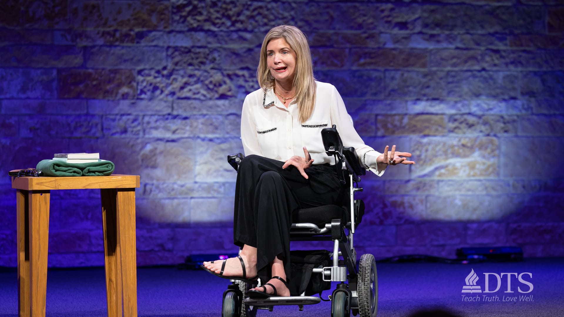 Katherine Wolf in her wheelchair speaking on stage at Dallas Seminary during chapel