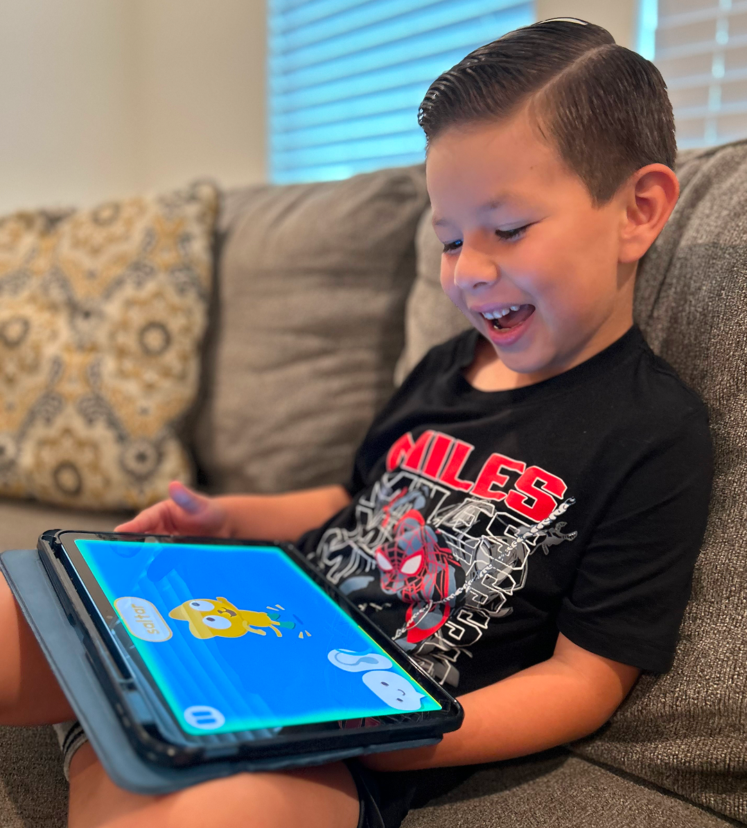 Emiliano engaging happily with Studycat Spanish speaking games, showing how interactive play builds confidence in new vocabulary.