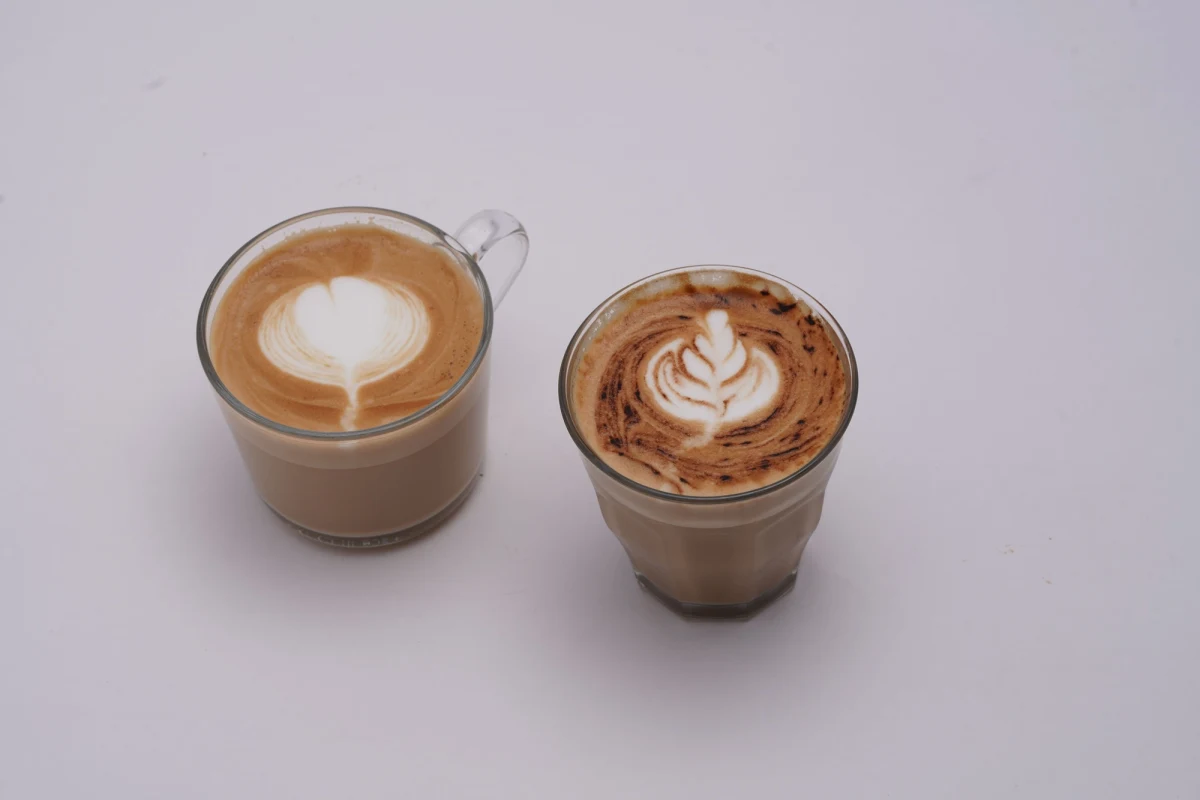 Cappuccino and latte side by side in glass cups, showing the difference in milk foam