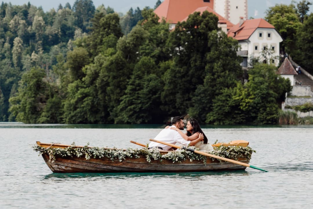 Newly engaged couple embracing on a wooden boat after the proposal.