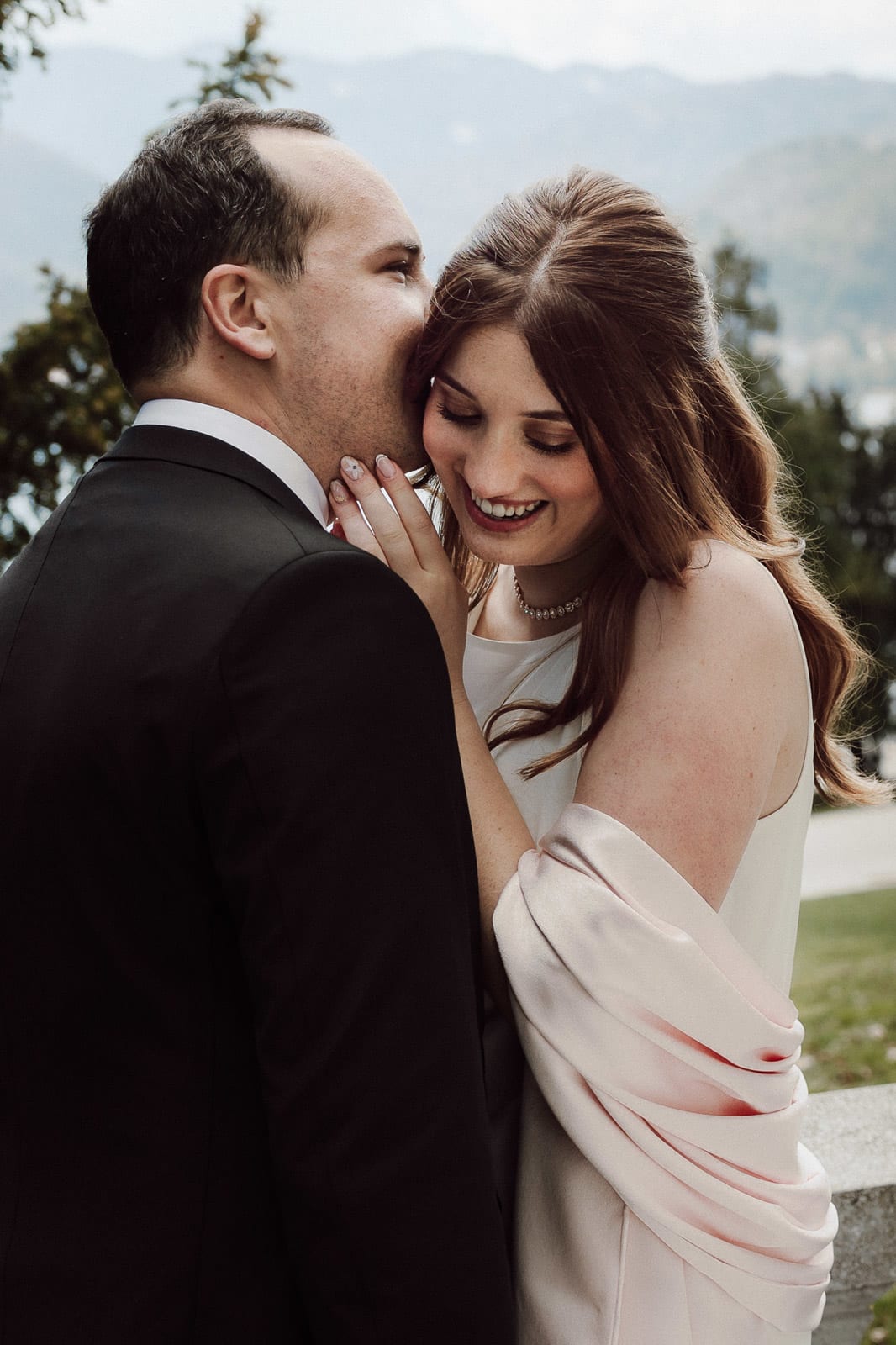 Couple sharing a quiet laugh, close and affectionate portrait.