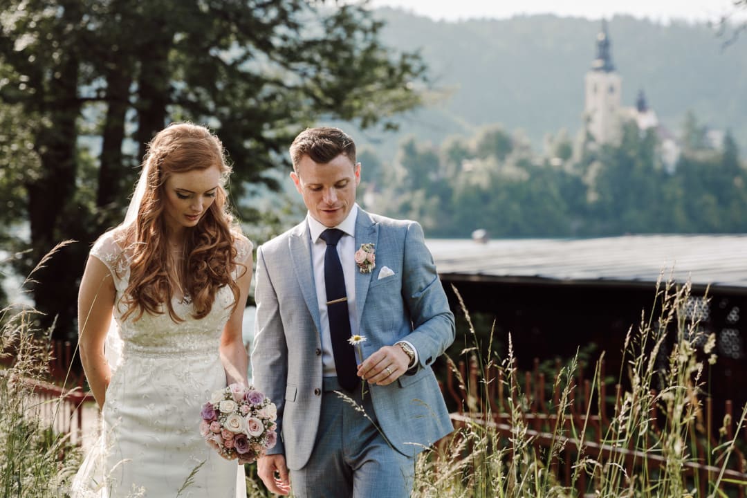Couple walking together with the church of Bled Island in the distance.