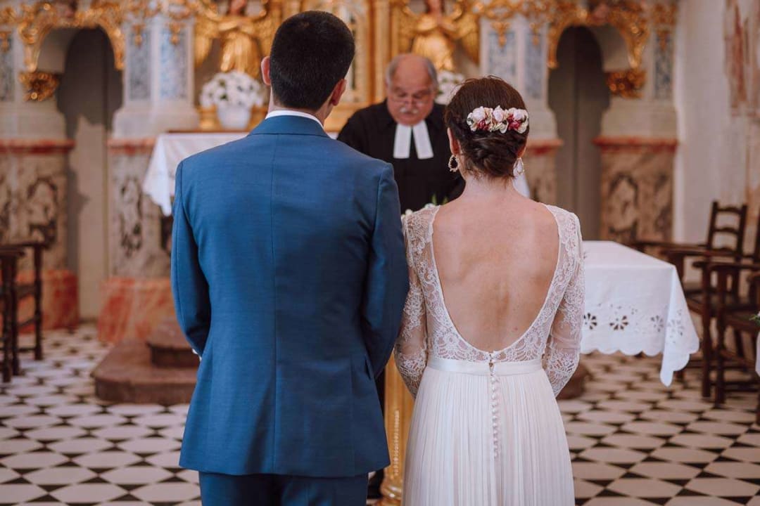 A bride and groom standing together in a beautifully decorated church during their wedding ceremony.