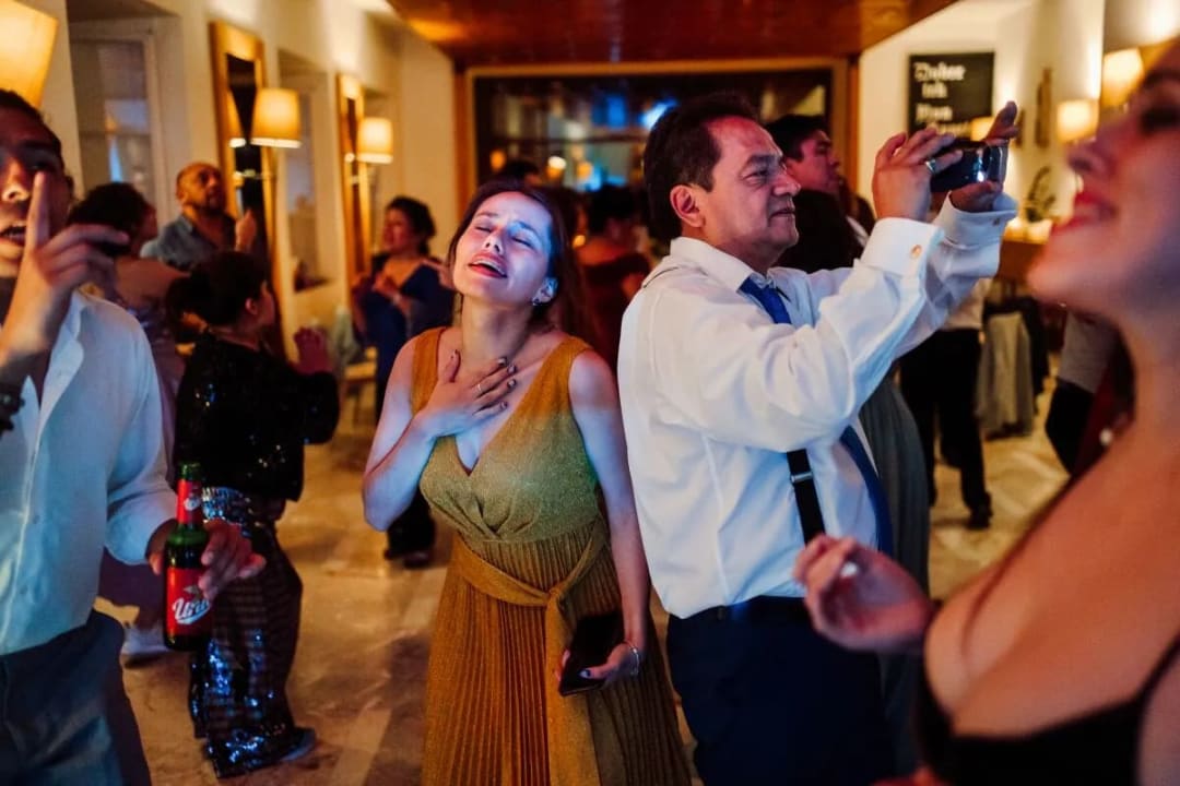 Guests joyfully dancing and celebrating at a wedding reception indoors.