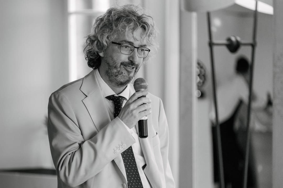 Emotional wedding speech moment at the reception with guests listening attentively.