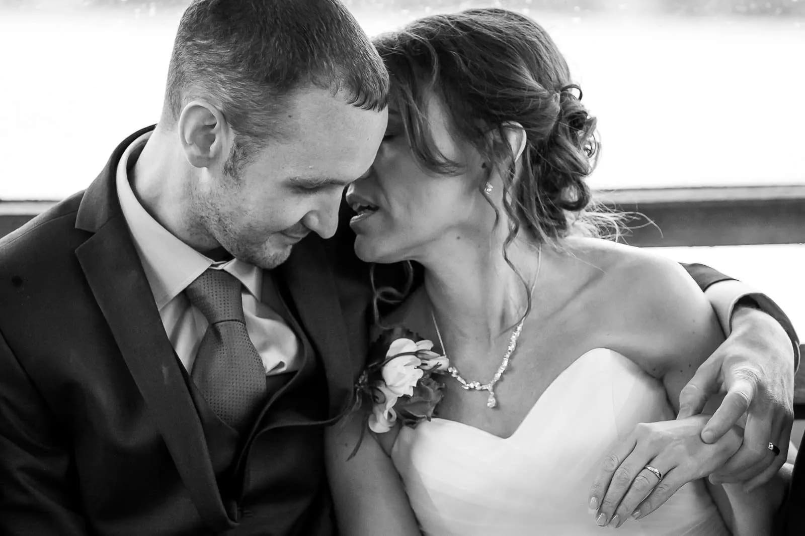 A bride and groom share an intimate moment, leaning close to each other with gentle smiles, capturing a tender and loving connection.