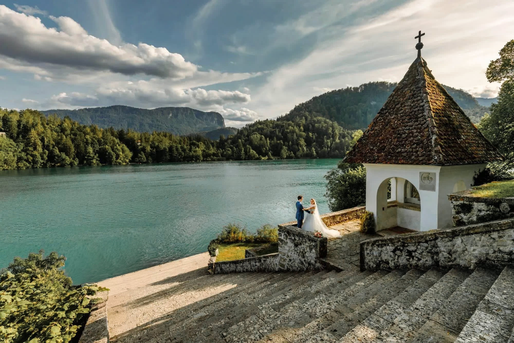 Wedding couple on Lake Bled Island, overlooking the lake and surrounding mountains.