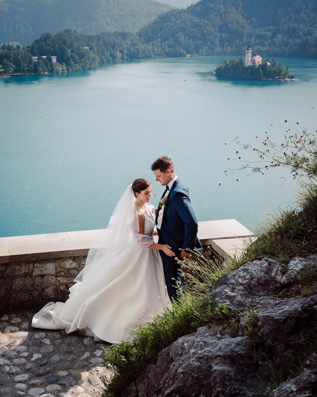 Bride and groom portrait overlooking Lake Bled, with Bled Island and the church in the background.