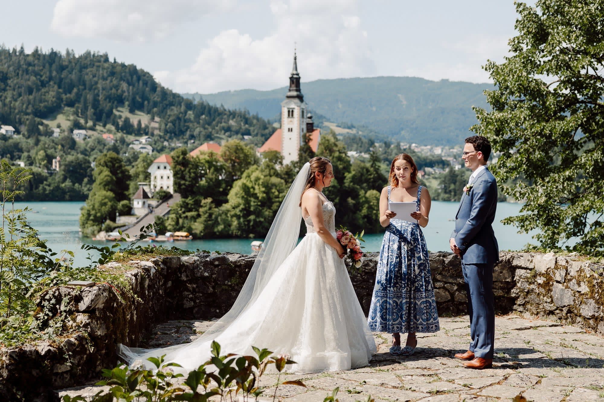 Intimate wedding ceremony at Vila Bled with Lake Bled and Bled Island church in the background, Slovenia.