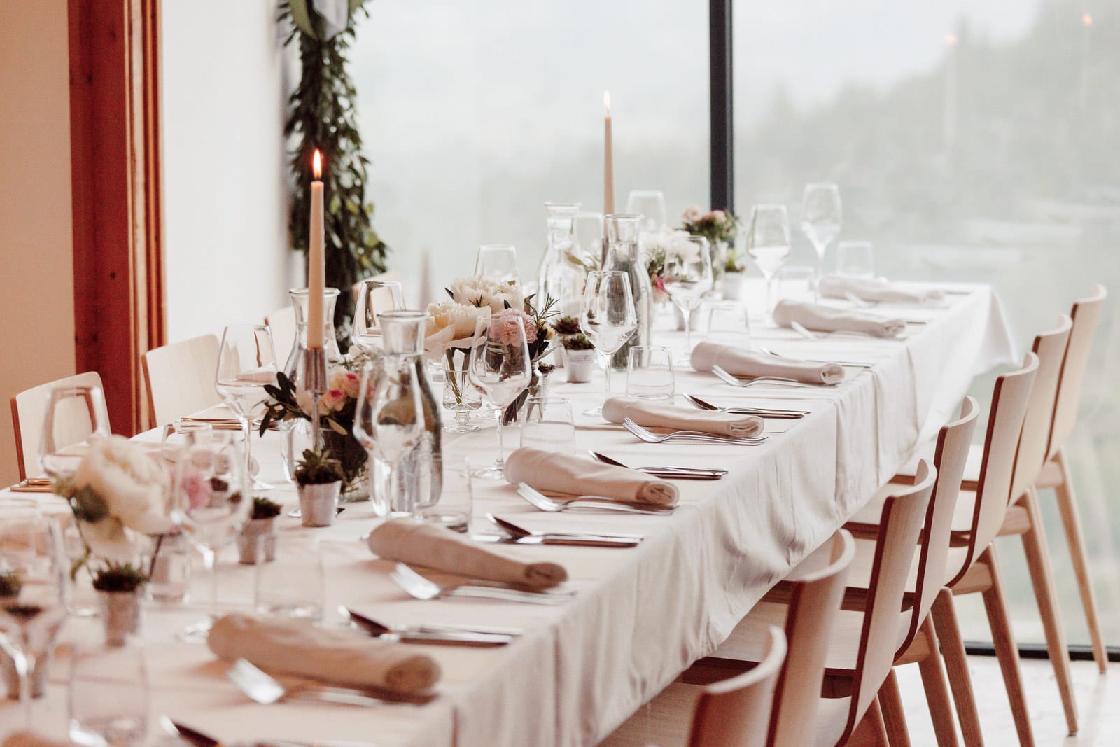 Long reception table with candles and elegant place settings at Bled castle, elegant styling.