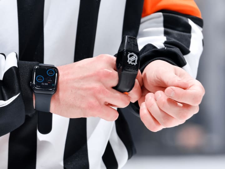 Wasit NHL mengenakan Apple Watch di atas es.