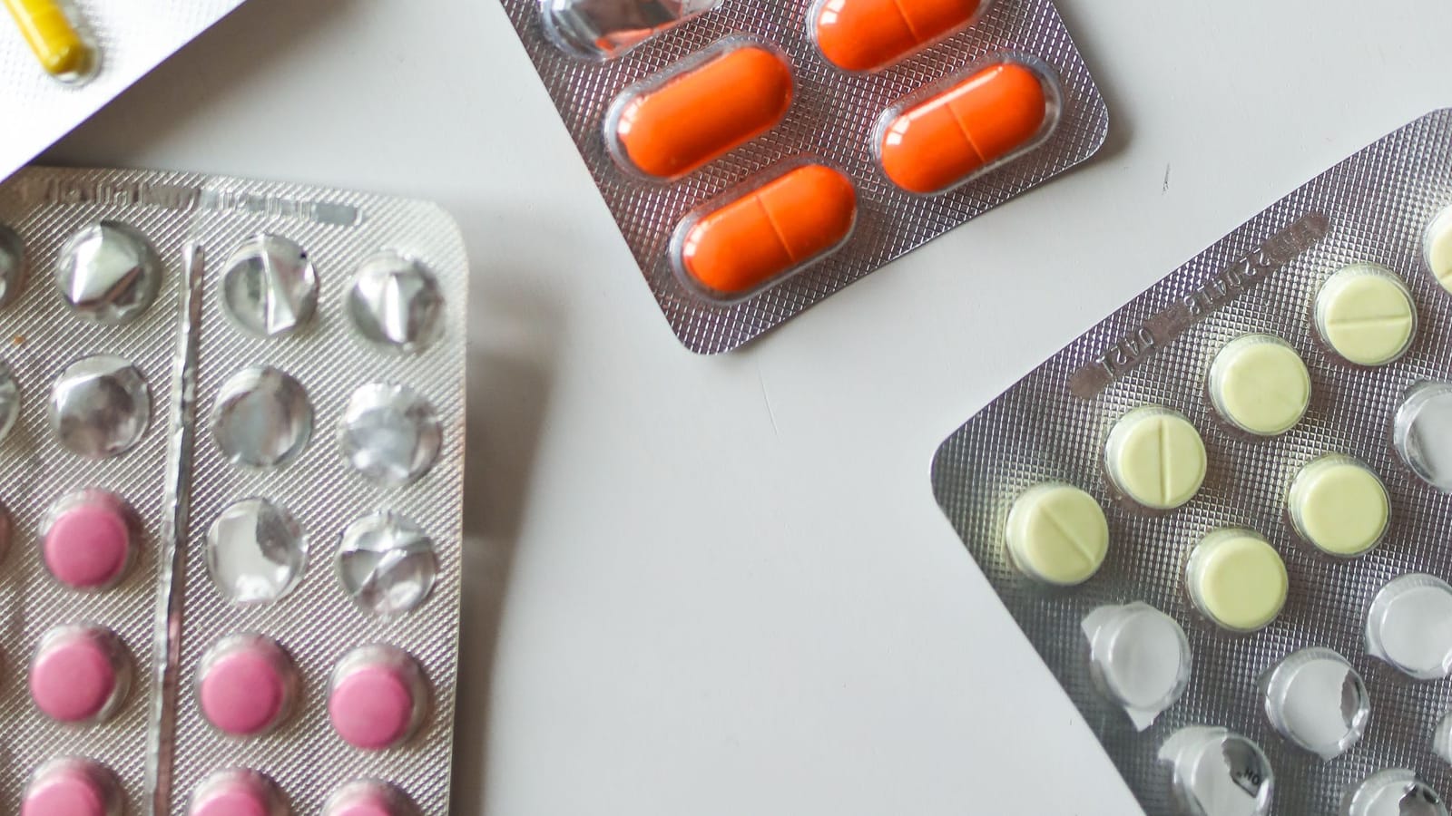 Blister packs of tablets and capsules on a white table