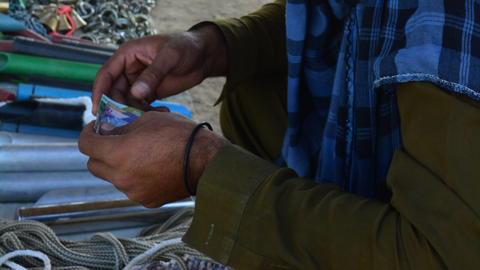 A stall owner in Taxila counting cash at the end of a sale