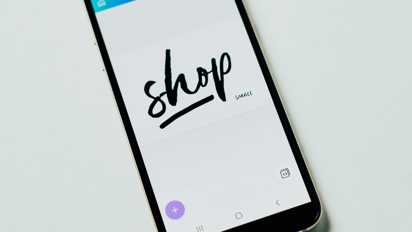 A smartphone showing a shop app on a white table