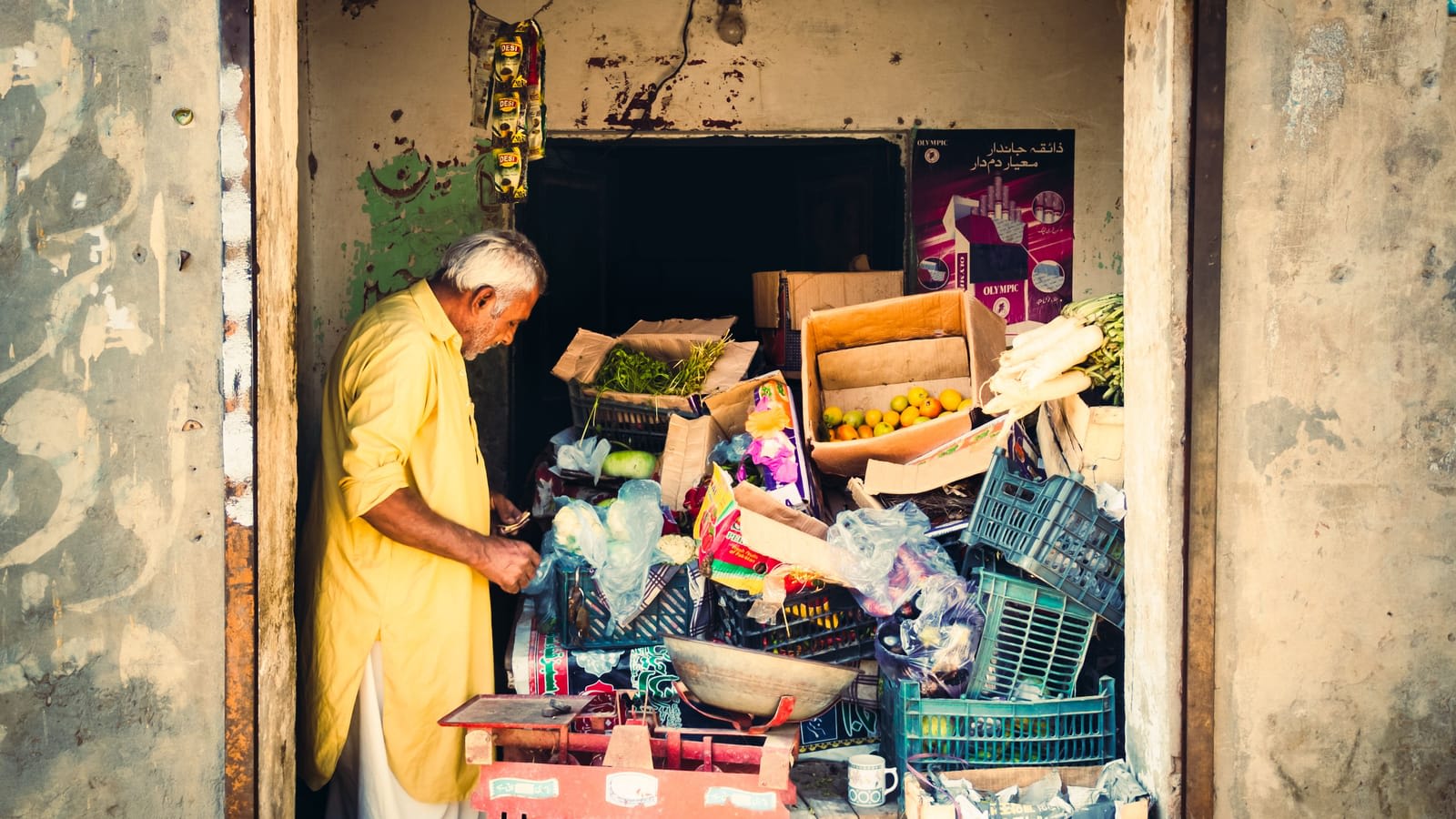 A shopkeeper in Punjab sorting through stock at the front of his shop