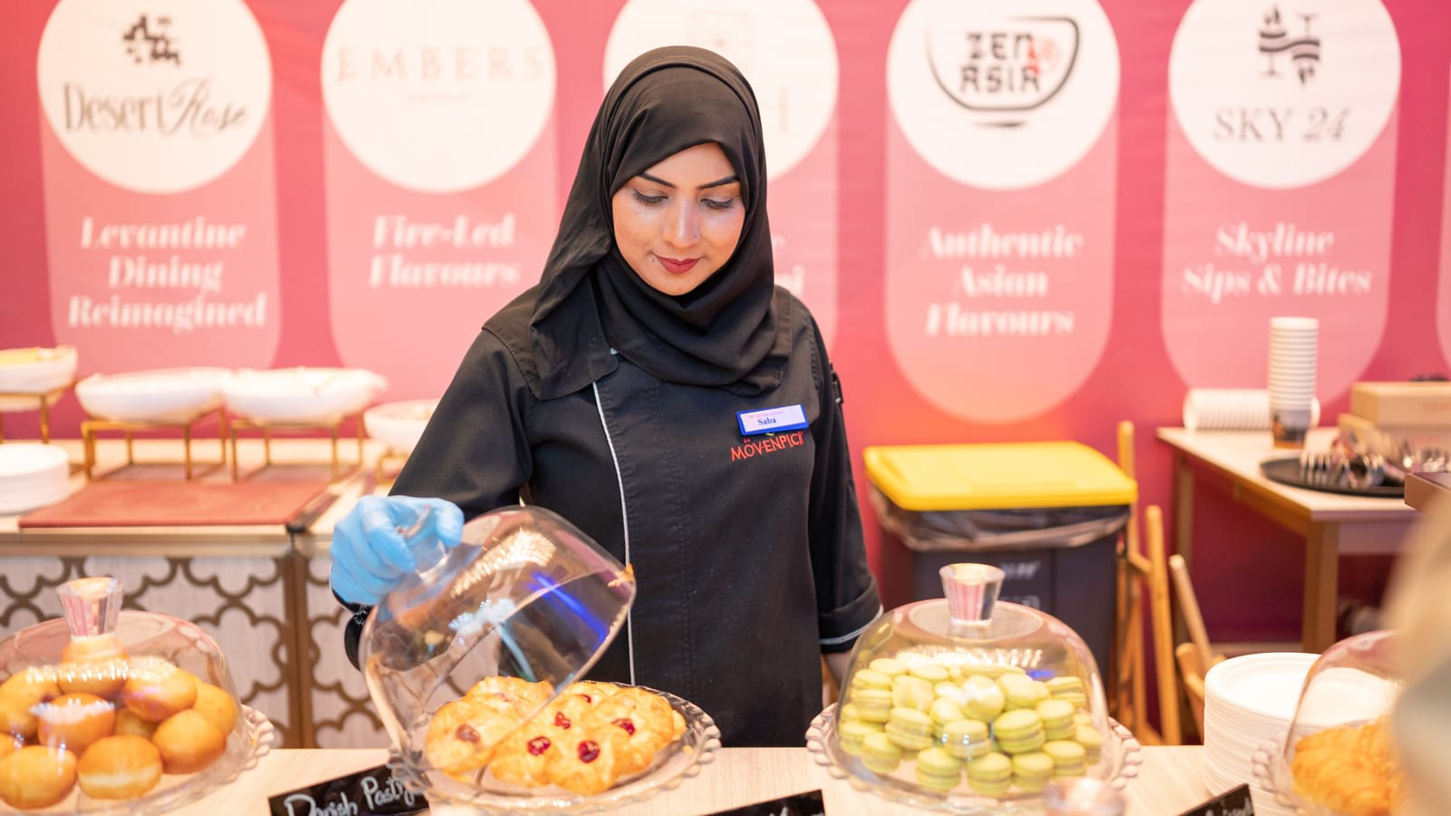 A baker serving pastries at a bakery counter in Islamabad