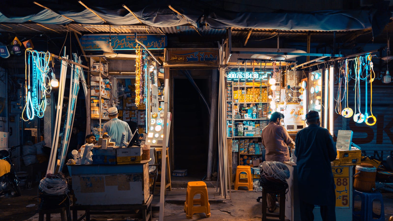 Shops lit up at a market in Faisalabad at night
