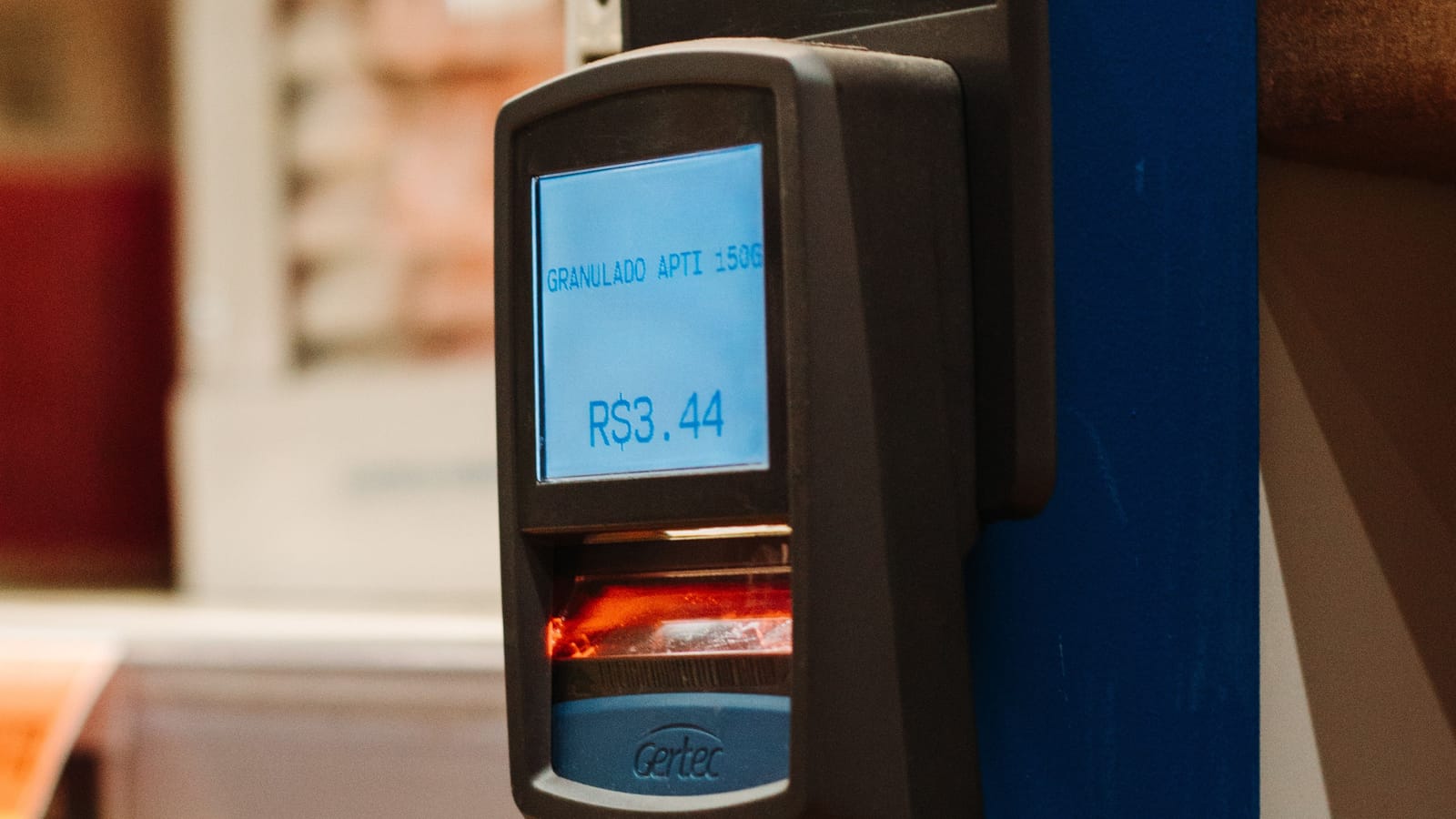 A barcode price checker mounted in a shop aisle showing a scanned price