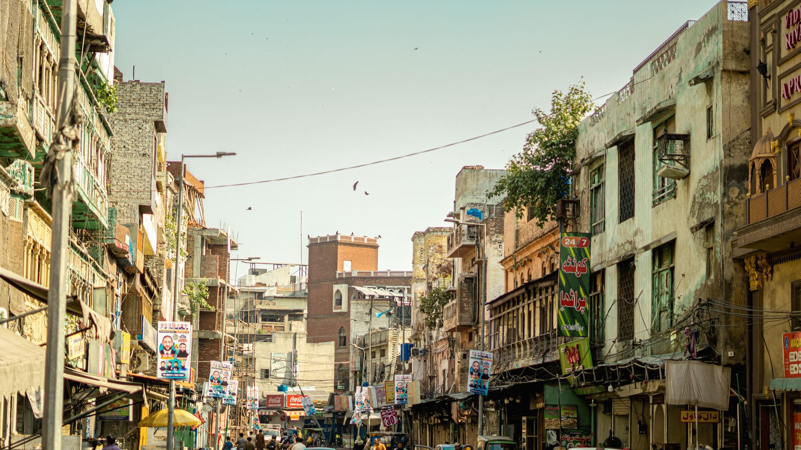 A busy market street in Lahore with shops on both sides