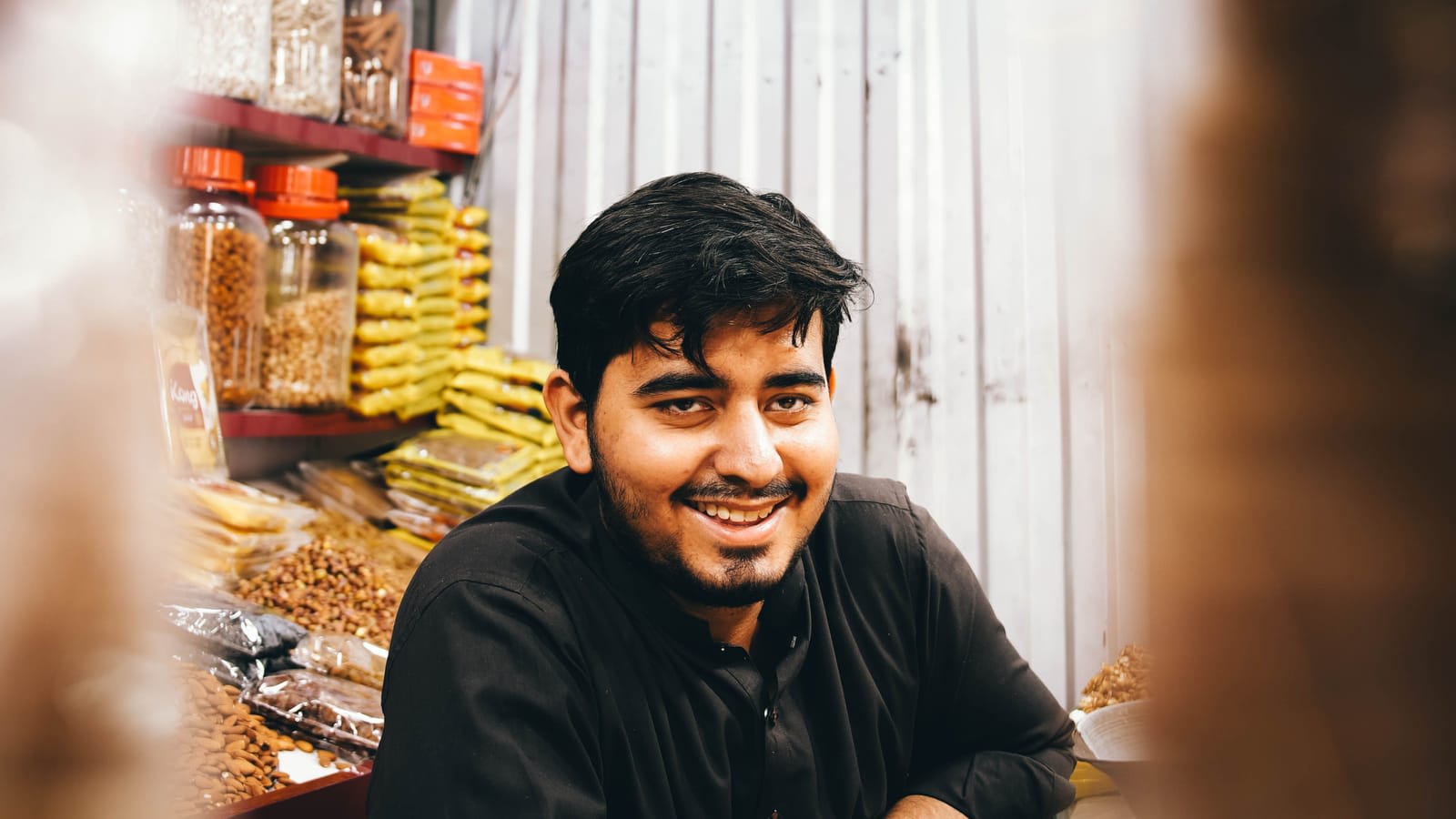 A smiling shopkeeper at his market stall in Karachi