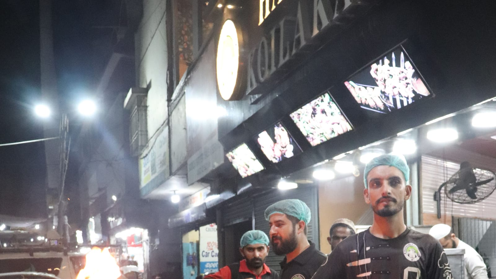 Cooks preparing karahi at a busy restaurant in Karachi at night