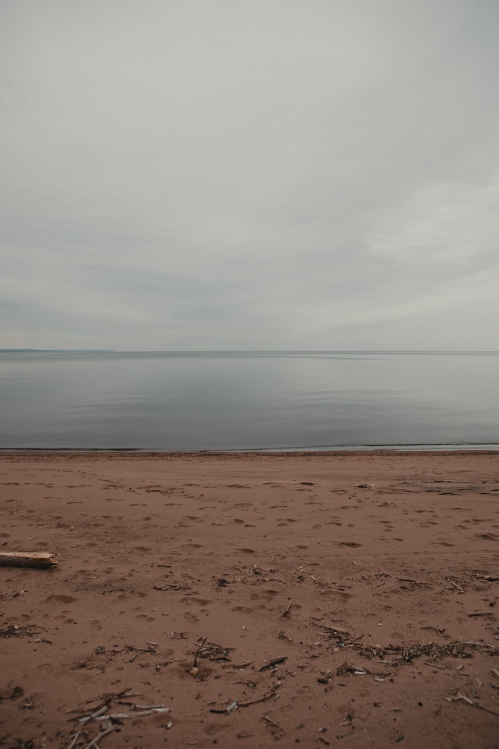 A quiet sand-and-pebble beach on the North Shore under a muted sky