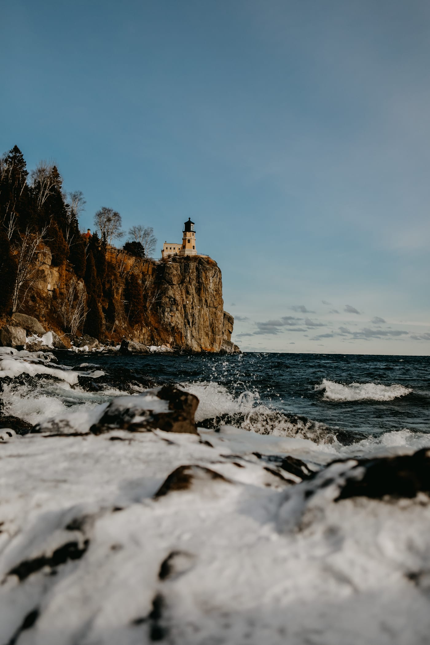Split Rock Lighthouse on its cliff above a snowy, icy Lake Superior shore