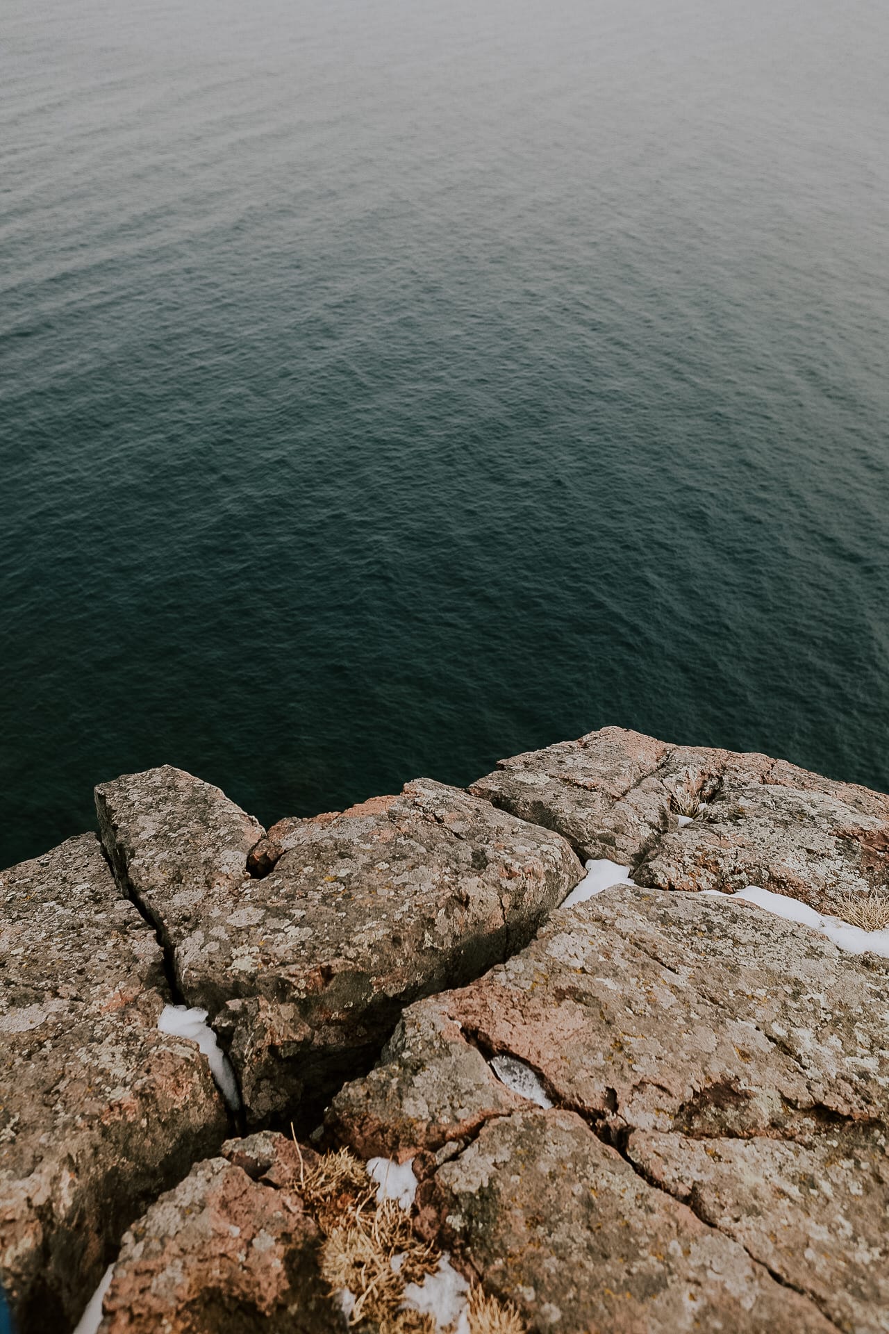 Clear teal Lake Superior water lapping against rock, seen from above