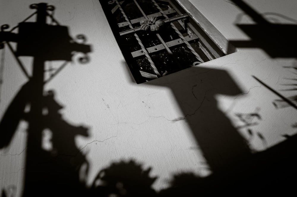 Shadows of headstones and crosses on a mausoleum wall in the cemetery in Chapala, Jalisco.