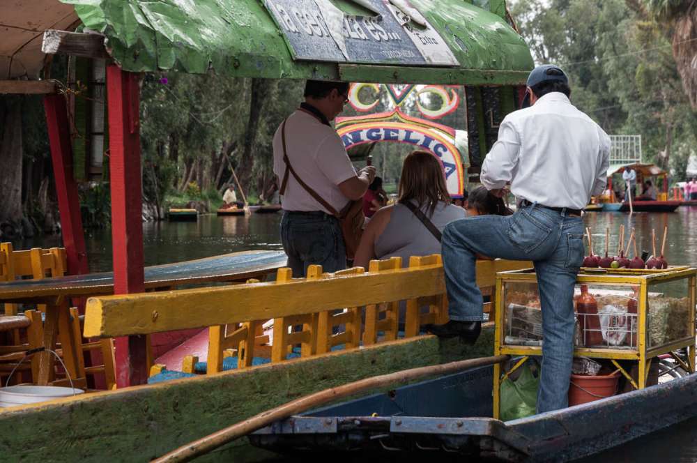 Man selling snacks to visitors at the floating gardens of Xochimilco.